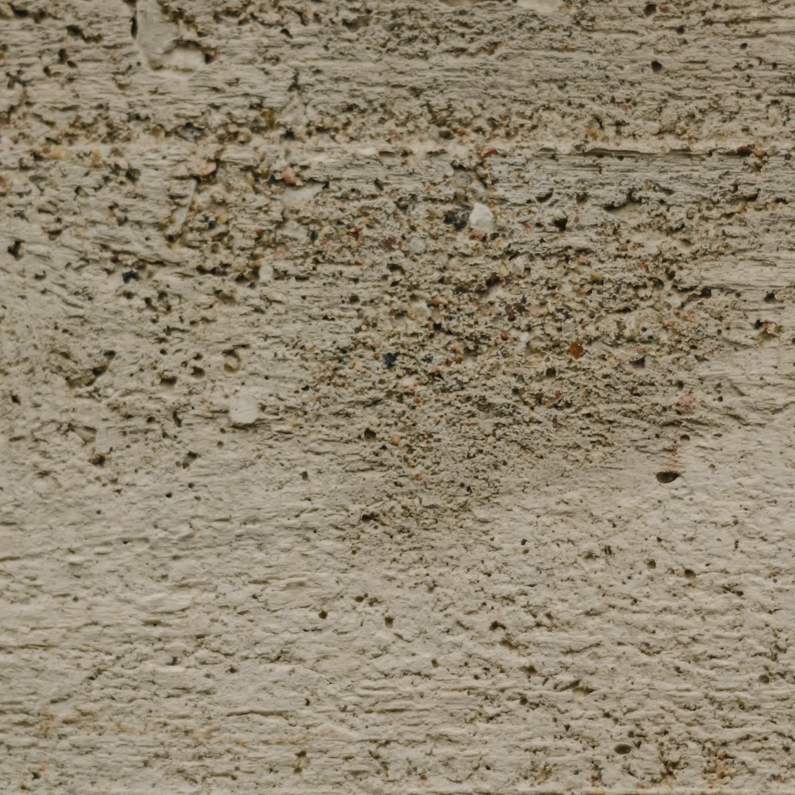 The face of cast concrete, aggregate showing through a warm finished surface.
